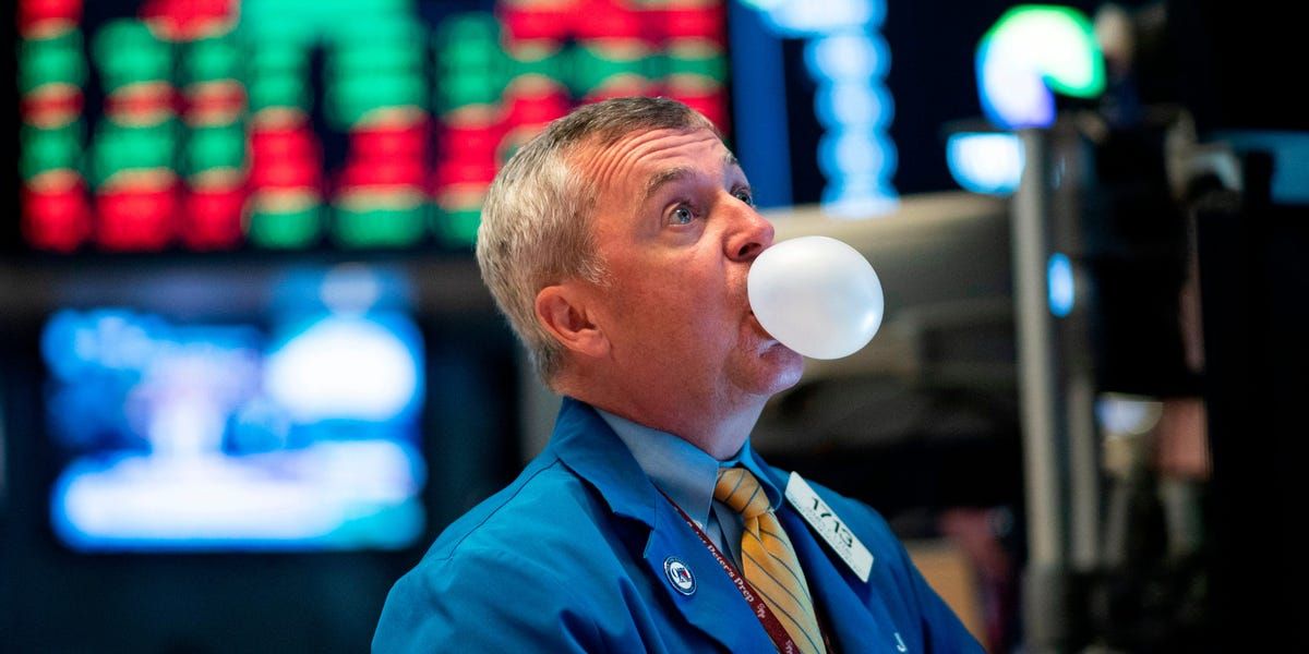 Un trader fait une bulle de chewing-gum devant des écrans de cotation