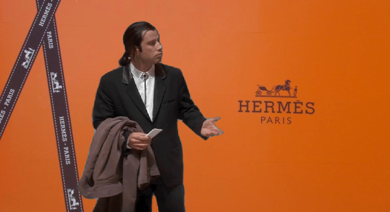Un homme en costume, l'air perdu, devant une vitrine orange Hermès Paris